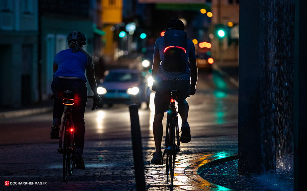 دو نفر در حال دوچرخه سواری در شب